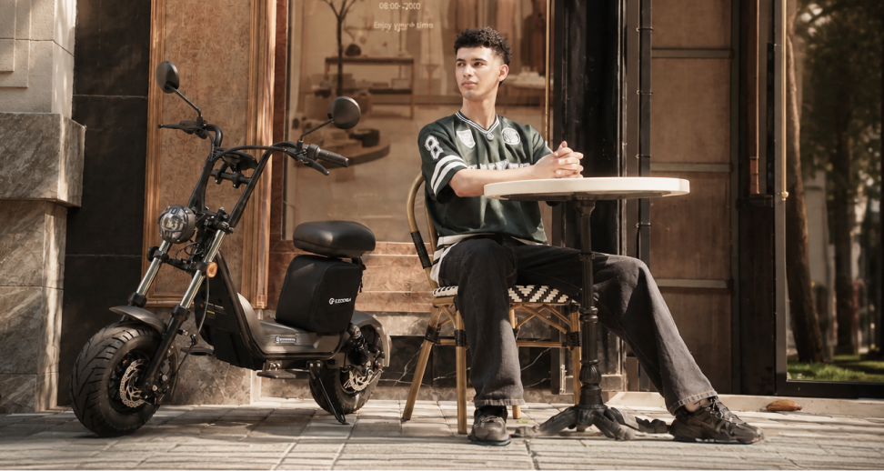 Rider seated beside an ECOROAD scooter